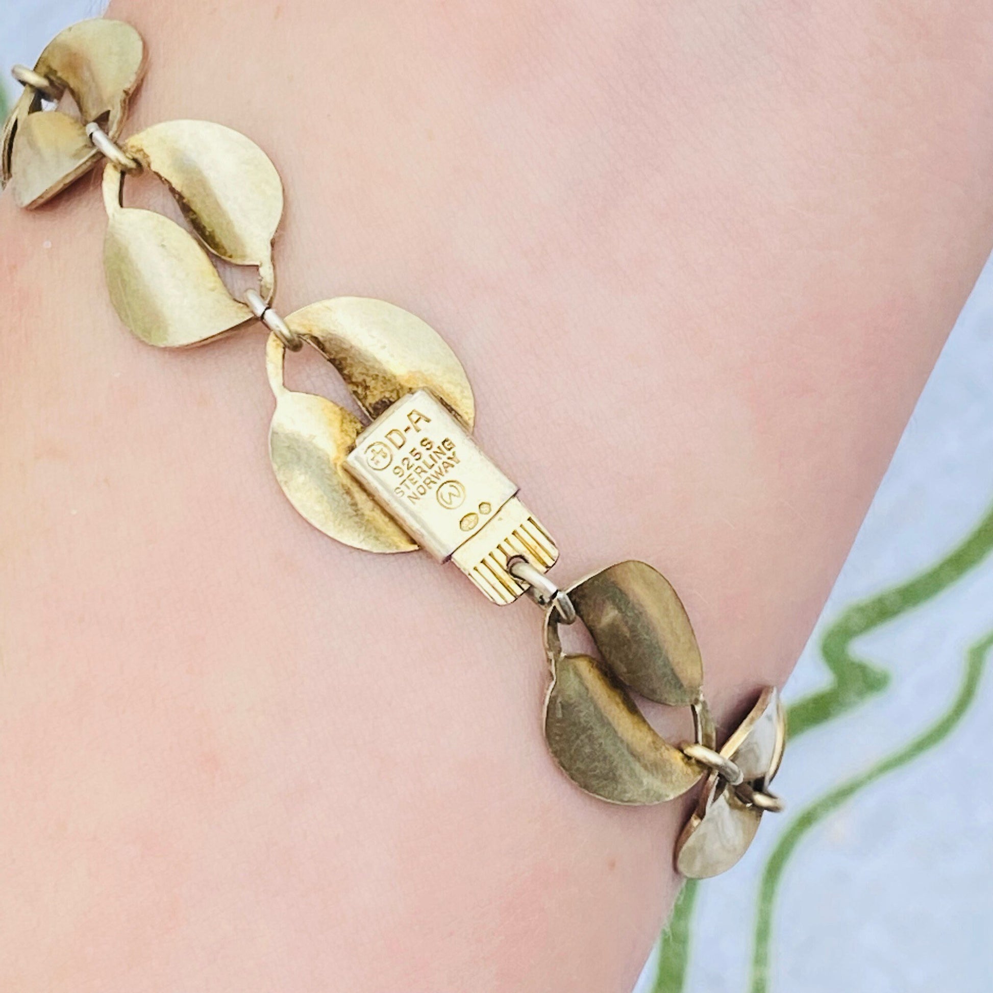 Vintage David Anderson Norway sterling silver guilloche enamel leaf bracelet with double leaf links in gold tone 925 silver, featuring an embossed "925S Norway D-A" hallmark on one of the links, showcasing the fine craftsmanship of Scandinavian jewelry design.