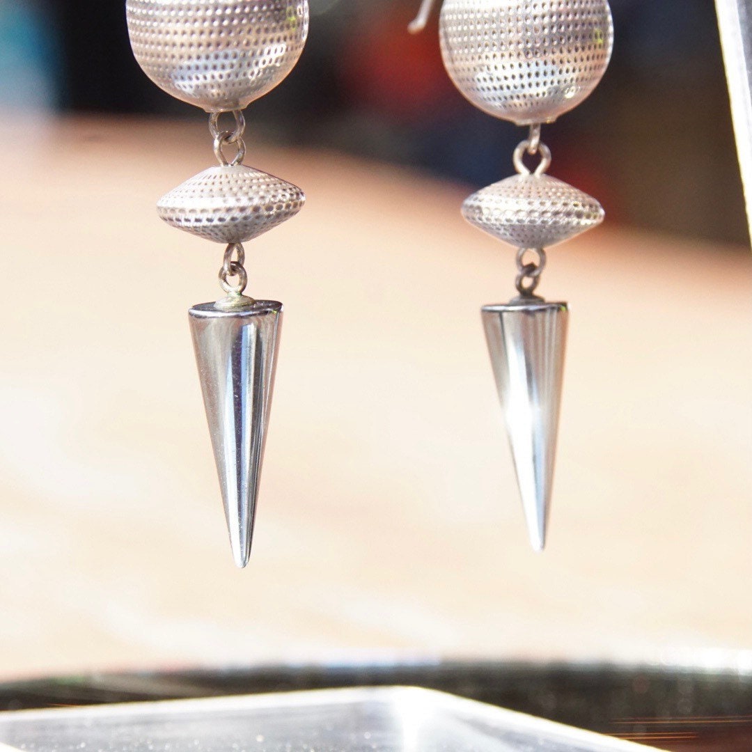 Vintage modernist silver ball and hematite spike dangle earrings, featuring reflective disco ball and gemstone accents, measuring 2 3/4 inches long.