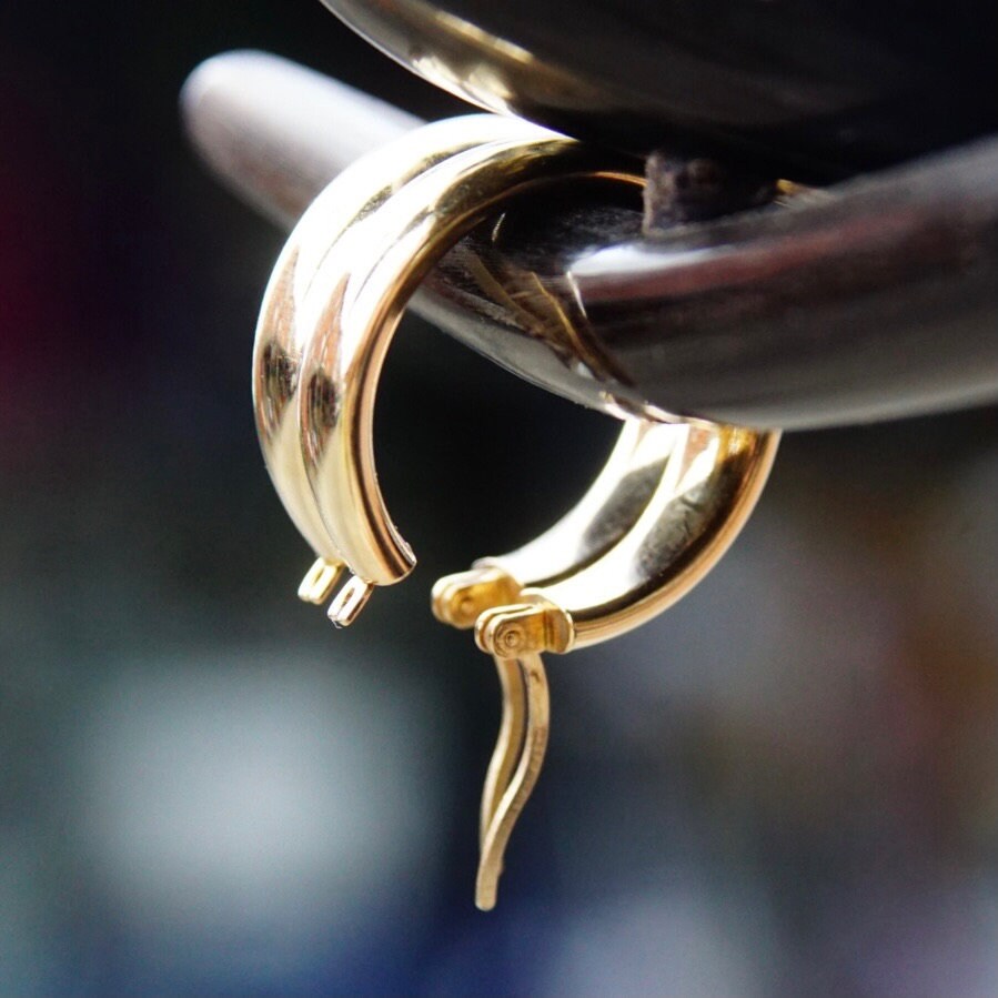 Vintage 14K yellow gold hoop earrings with latch back closure, signed Saks Fifth Avenue, measuring approximately 1 1/2 inches long.