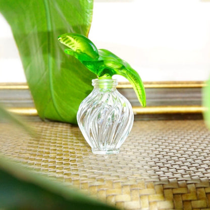 Vintage Nina Ricci Lalique perfume bottle with two frosted green glass doves perched on a clear ridged glass bottle, 3.75 inches high.