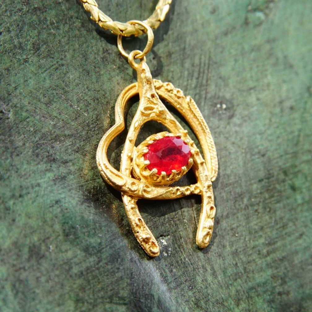 Vintage 14K yellow gold wishbone heart pendant necklace with faceted ruby, featuring cut-out design on a 2mm flat gold chain, 20.5 inches long.