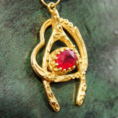 Vintage 14K gold wishbone heart pendant necklace with faceted ruby, intricate cutout design, and delicate 2mm flat gold chain, 20.5 inches long.