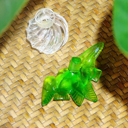 Vintage Lalique for Nina Ricci perfume bottle featuring two frosted green glass doves perched on a clear ridged glass bottle with stopper, measuring 3.75 inches tall.