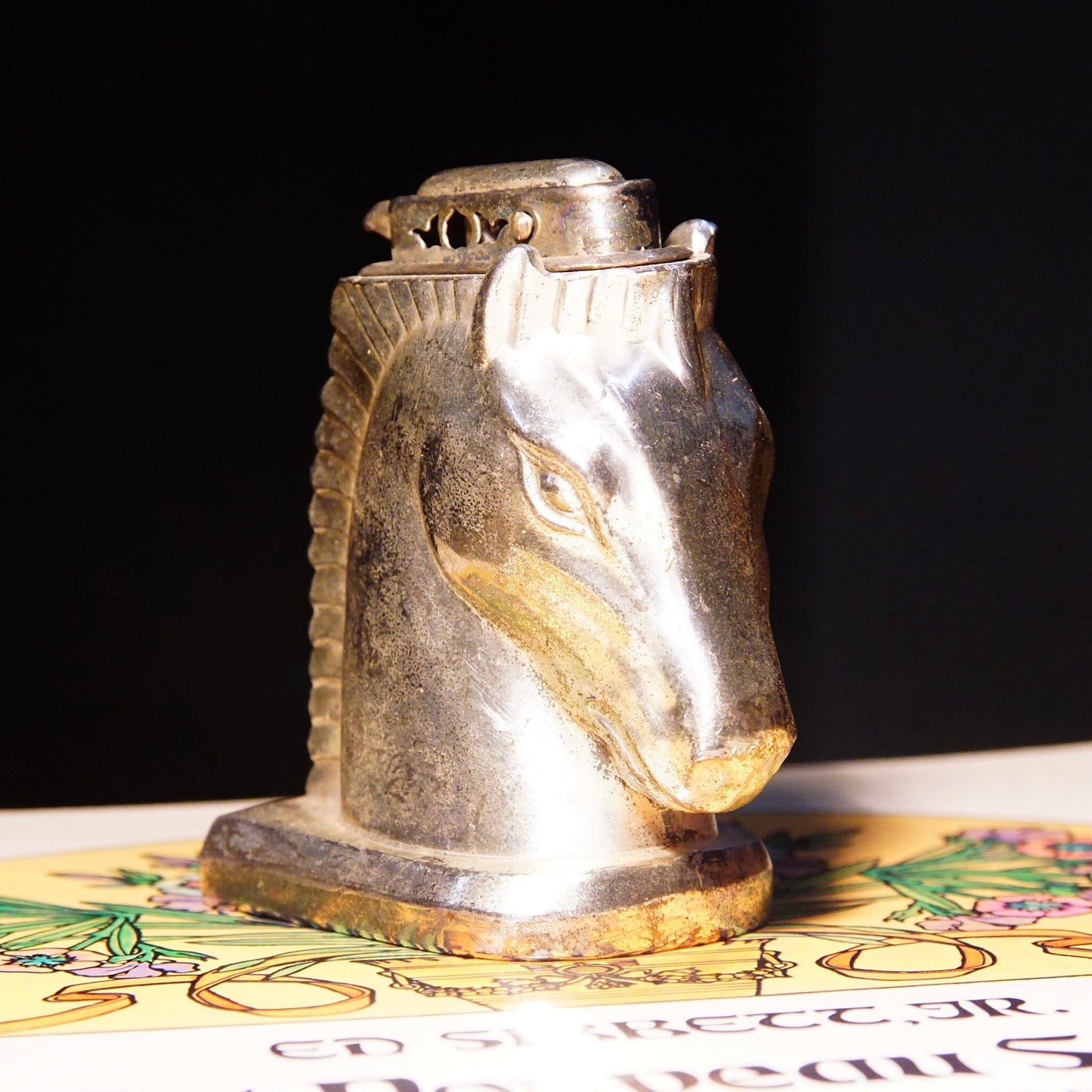 Vintage silver-plated horse head table lighter, made in Occupied Japan, collectible butane lighter, not tested, measuring 2 3/4 inches tall, displayed on ornate gold mat.