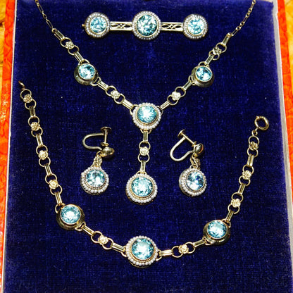 Vintage 14K gold aquamarine pearl seed jewelry set with matching Y-pendant necklace, bracelet, screw back earrings and brooch featuring brilliant blue stones, displayed in velvet case.