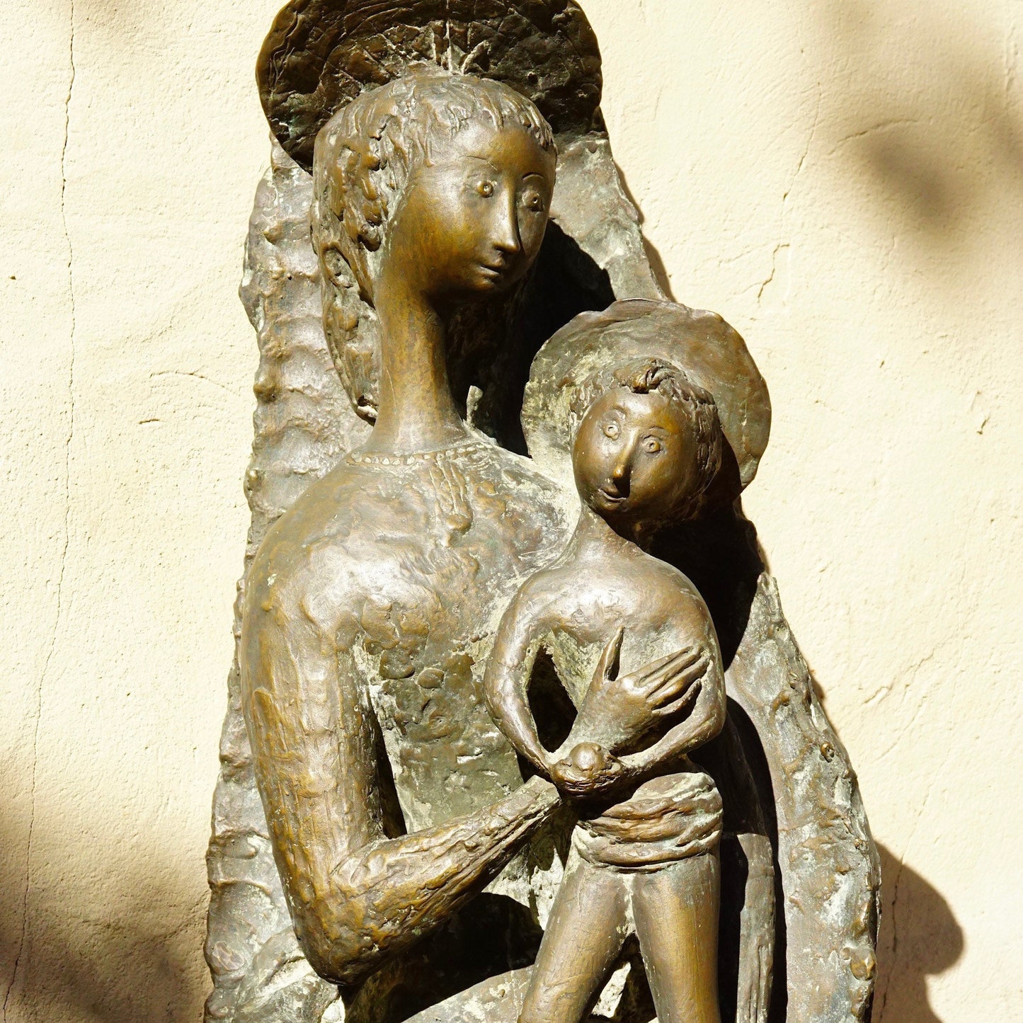 Vintage signed Toni Furlan bronze sculpture of a stylized Mother Mary holding Baby Jesus, an abstract modernist Italian religious statue measuring 36 inches tall.