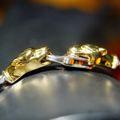 Vintage Italian Sterling Silver and Gold Panther Figaro Chain Bracelet closeup featuring heavy 7mm silver chain links and gold panther head clasp against blurred background