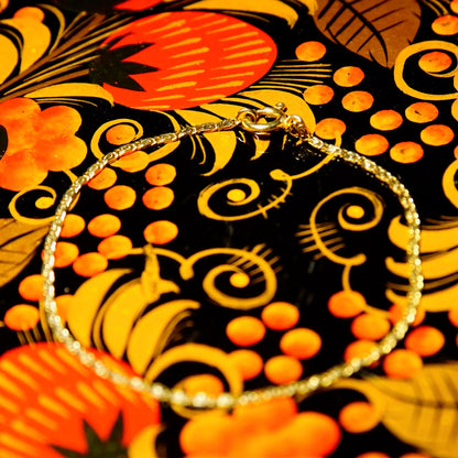 Vintage floral pattern in orange, yellow and black colors featuring swirling designs and circular shapes resembling flowers or fruit. The intricate pattern has an Art Nouveau style against a black background.