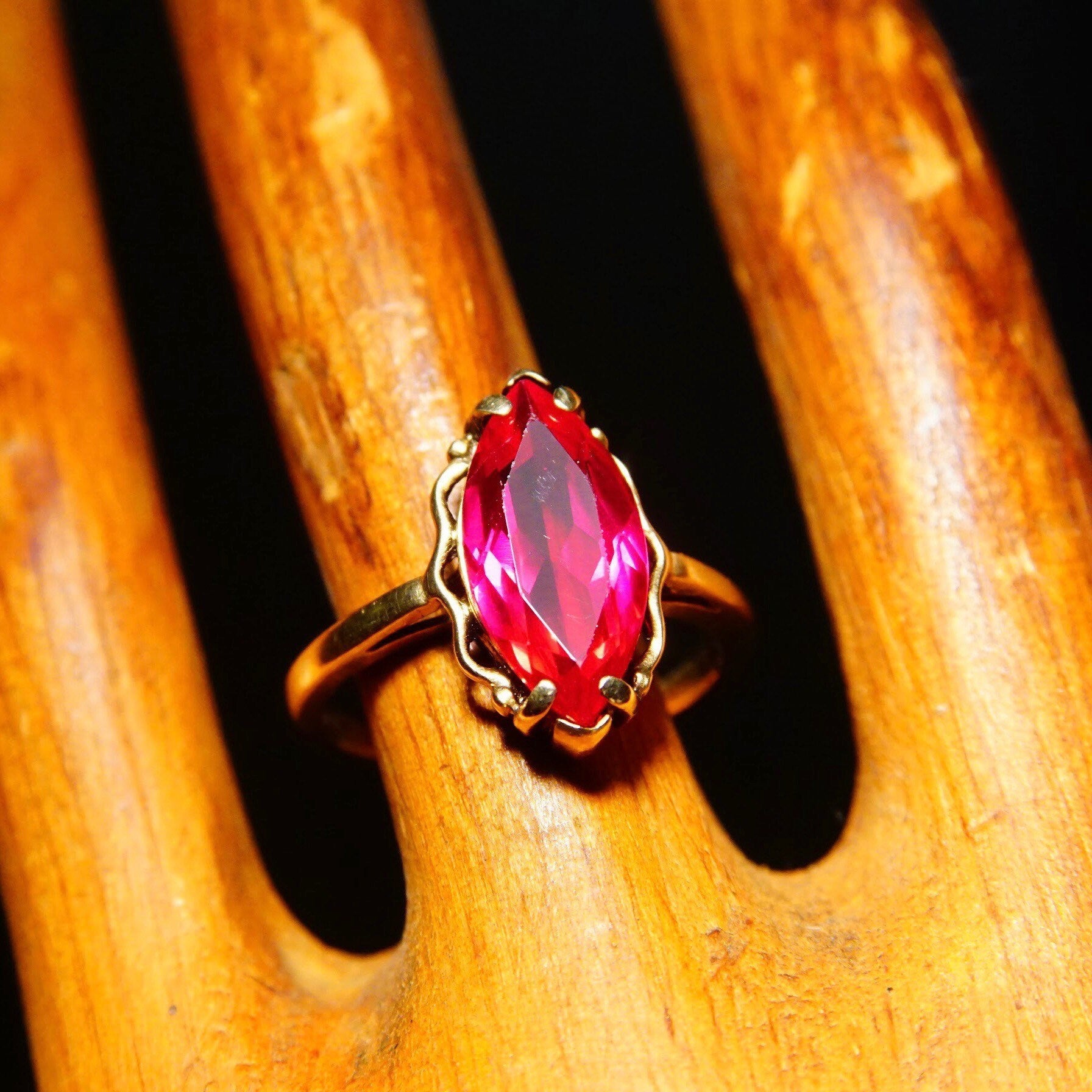 Antique 10K yellow gold ring featuring a marquise-cut faceted red ruby gemstone set in a straight gold band, ring size 6 1/4 US.