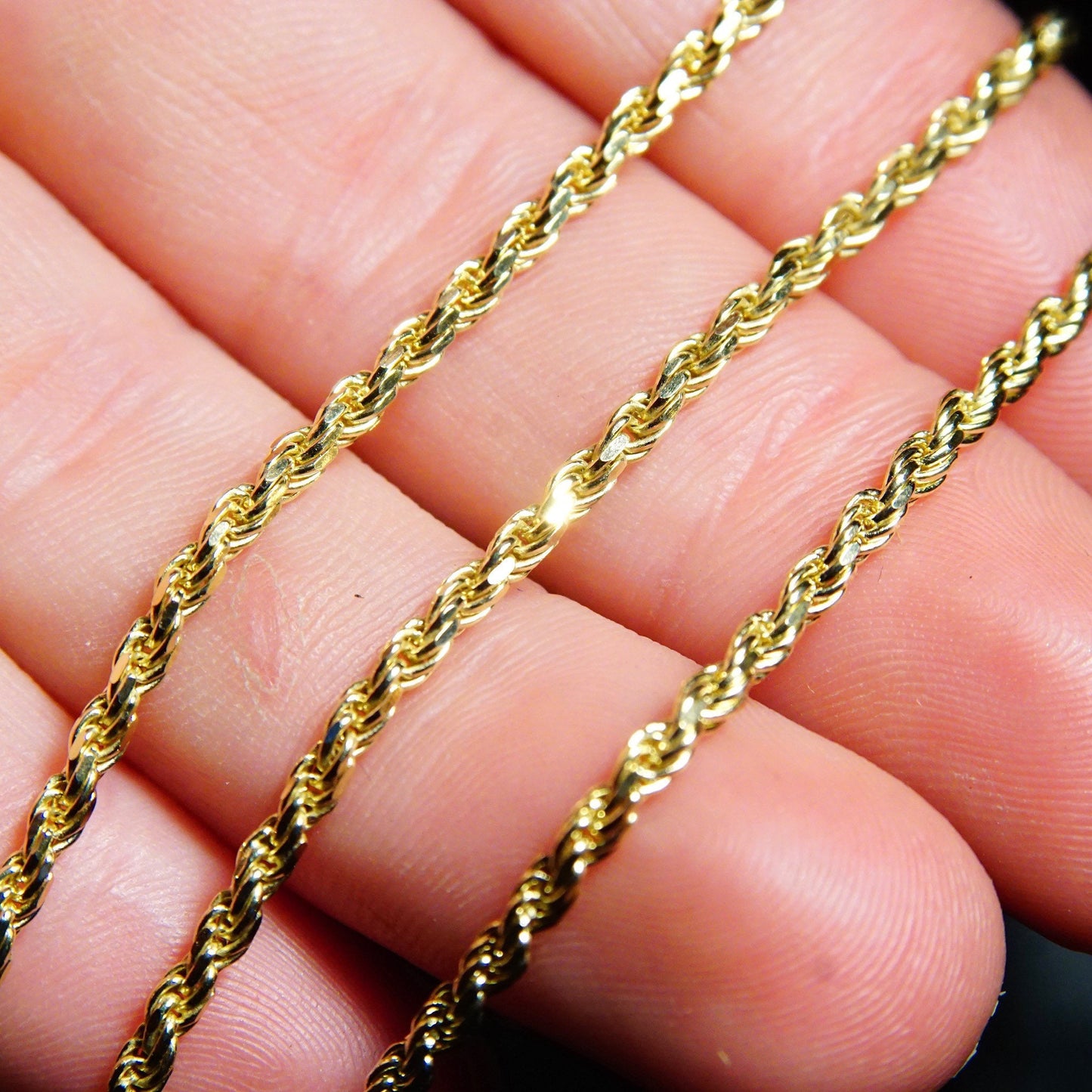 Vintage 14K yellow gold rope chain necklace against fingers, 2.5mm thick and 24 inches long, suitable for unisex wear or pendants, 585 gold jewelry.