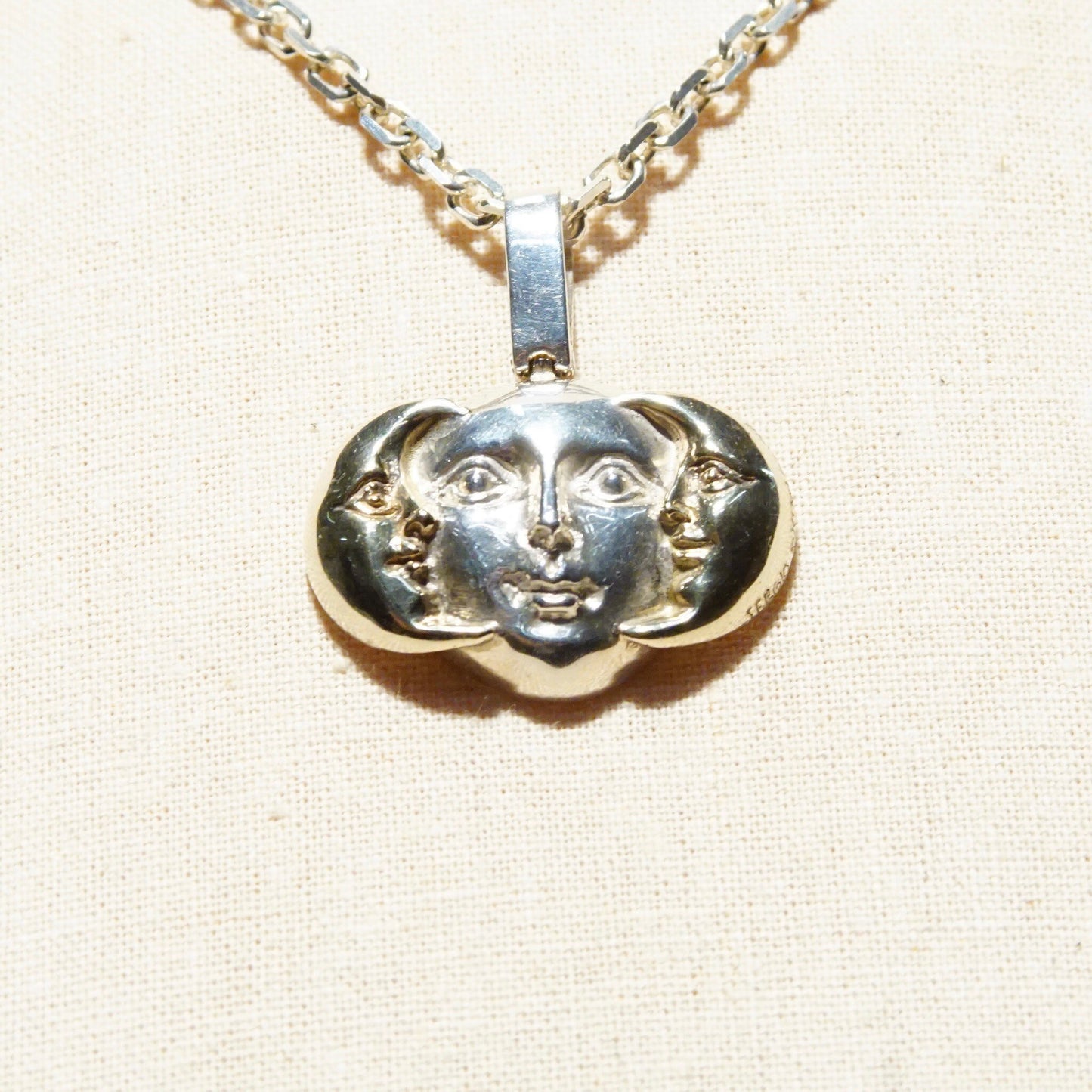 Vintage Sergio Bustamante sterling silver pendant necklace featuring a two-tone sun and moon face design with gold crescent moons, marked 925 MEX, measuring 1 1/2 inches long.