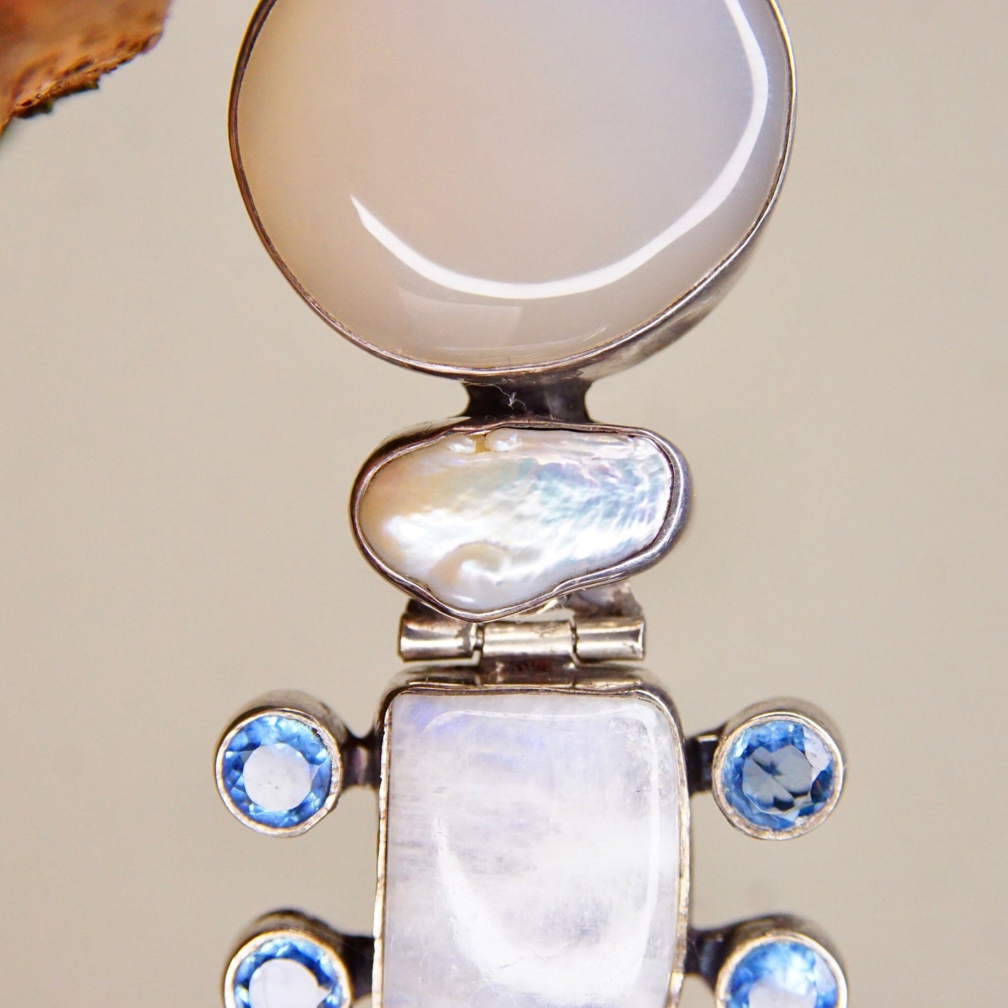 Vintage abstract modernist hinged sterling silver pendant with moonstone, mother of pearl, quartz, and purple/blue gemstones, measuring 3 1/8 inches in length.