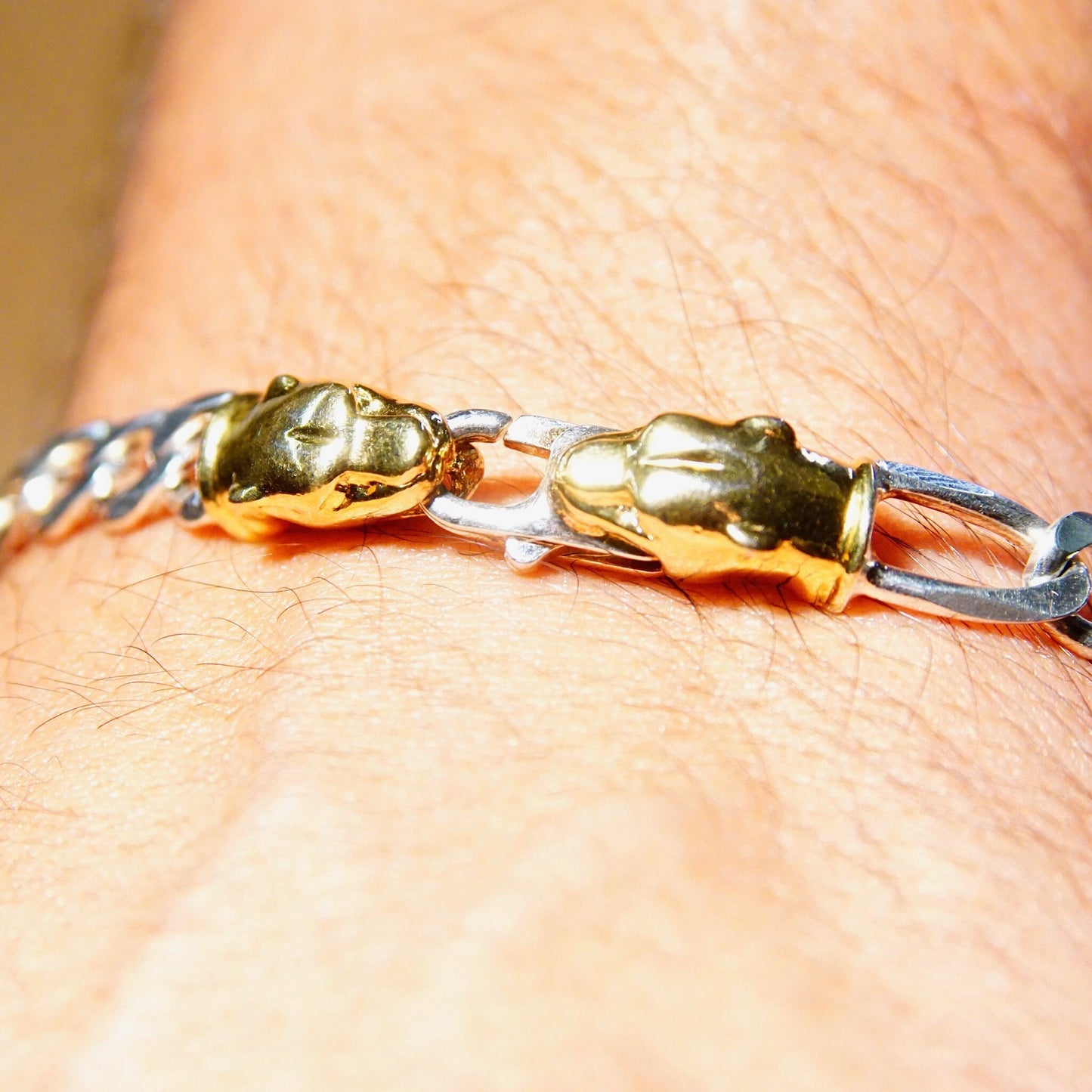 Vintage Italian sterling silver and gold panther figaro chain bracelet featuring 7mm heavy silver links and accent gold panther clasp, measuring 8 1/4 inches in length.