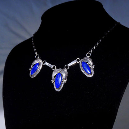 Vintage Native American sterling silver lapis lazuli pendant necklace featuring a 3-stone pendant with engraved leaf settings on an oval link chain measuring 20 3/4 inches in length.