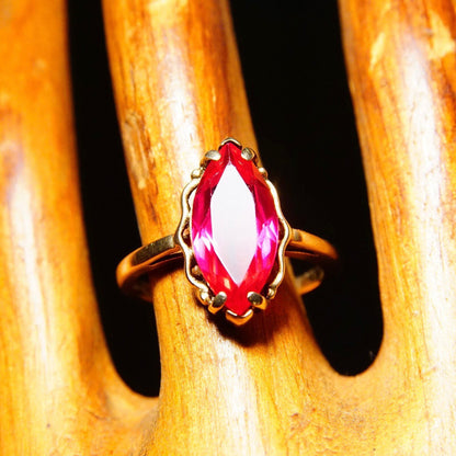 Antique 10K yellow gold ring featuring a marquise-cut faceted red ruby gemstone set in a straight gold band, jewelry size 6 1/4 US.