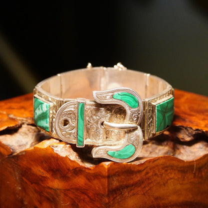 Antique Victorian silver bracelet with malachite inlay, featuring ornate etched designs and a buckle closure. The bracelet has gemstone accents and measures 7 1/8 inches long. It exhibits a belt buckle style with interconnected silver links.