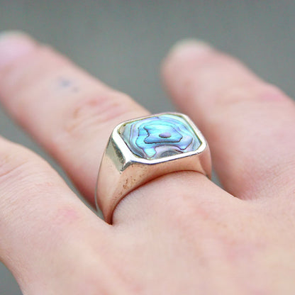 Vintage sterling silver signet ring with iridescent abalone shell inlay, unisex jewelry in a size 9 1/2 US, displayed on a hand.