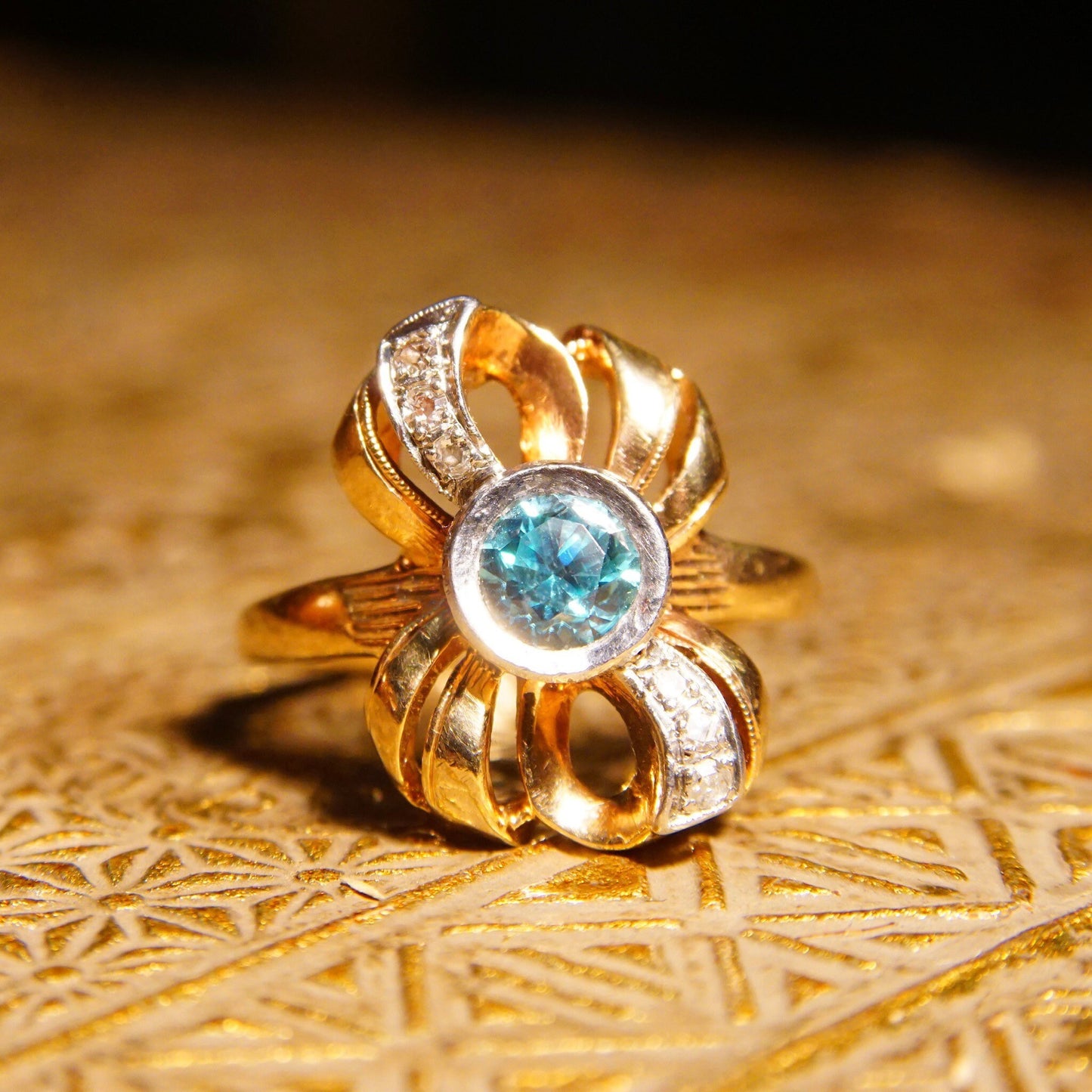 Antique 10K gold blue topaz and diamond bow ring with ribbon setting and white gold accents, size 6 3/4 US, crafted by JR Woods & Sons, featuring a brilliant blue gemstone at the center.