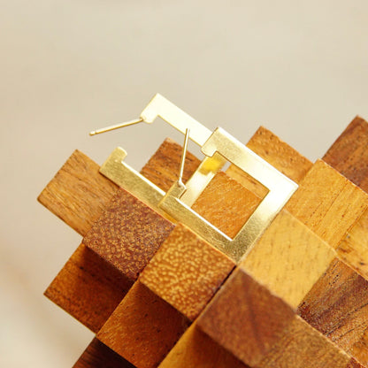 Geometric wooden blocks arranged in an abstract sculptural composition, featuring various warm brown tones and textures illuminated by soft lighting.