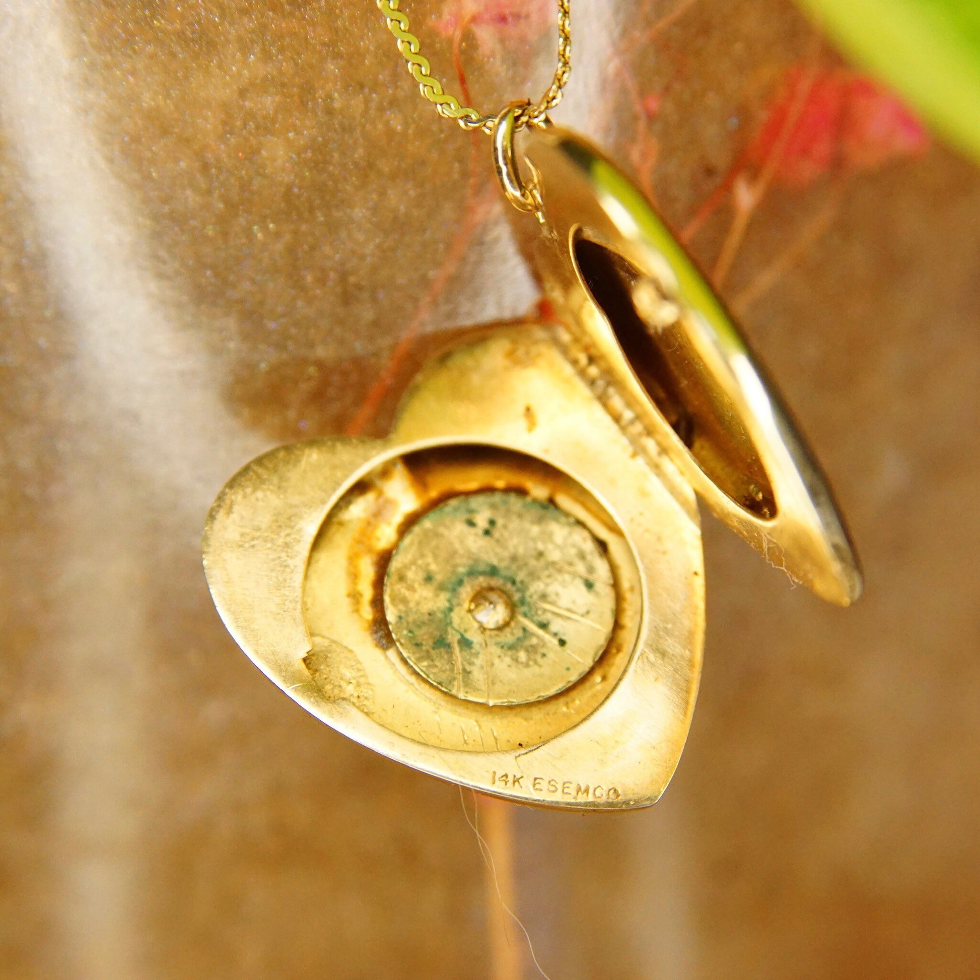 Antique 14K gold heart locket necklace with tiny mine cut diamond starburst design, featuring two picture frames inside, from the Victorian era by EMESCO jewelry company.