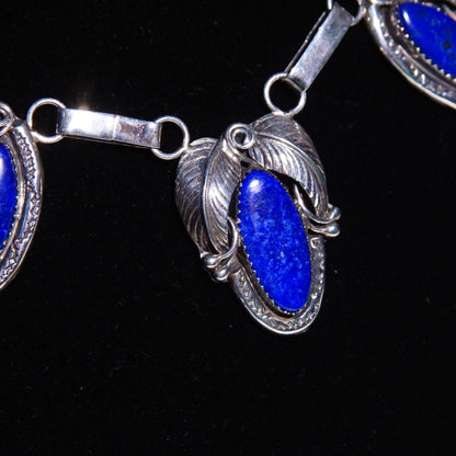 Vintage Native American sterling silver lapis lazuli pendant necklace featuring an engraved three-stone leaf design on an oval link chain, measuring 20 3/4 inches in length.