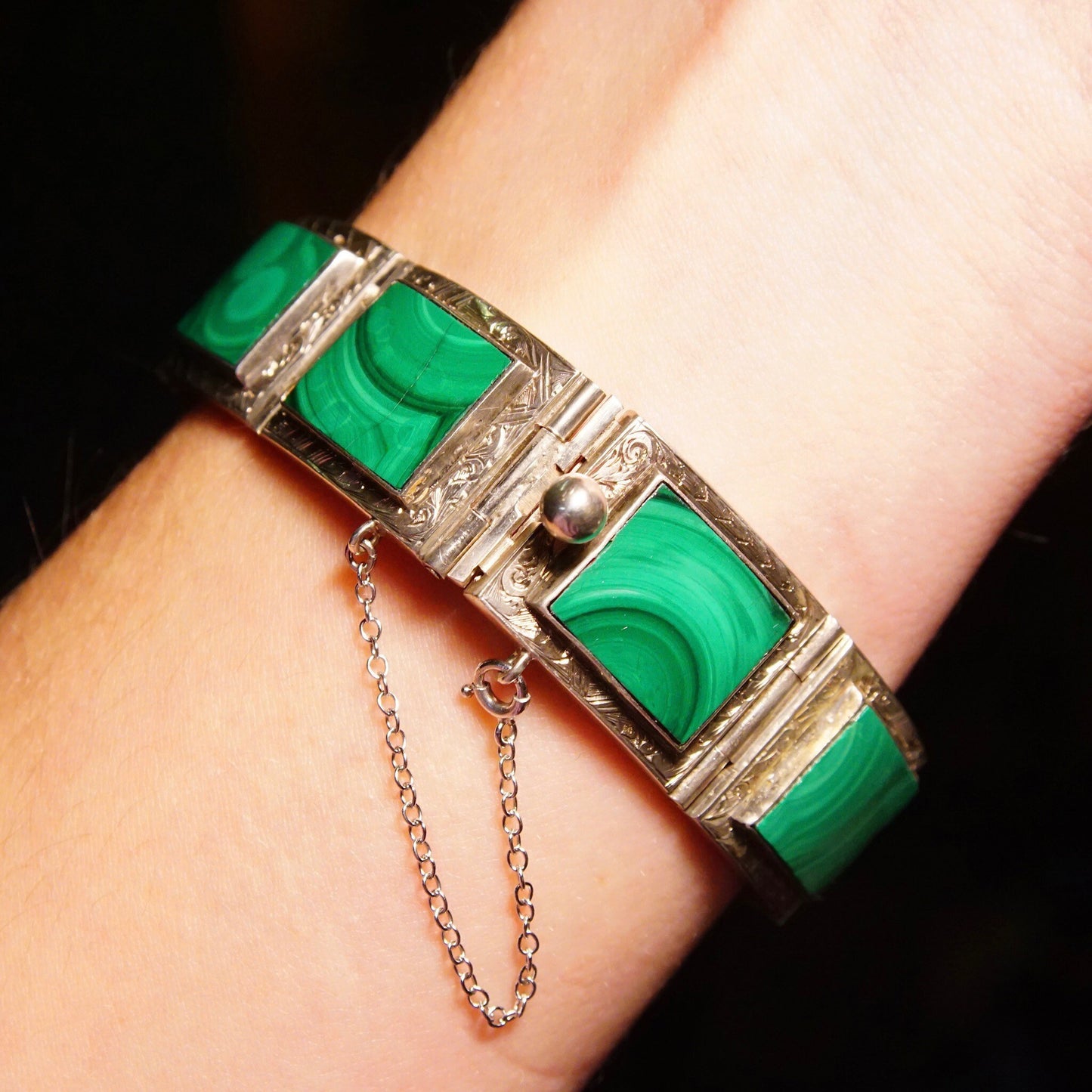 Antique Victorian silver bracelet with malachite inlay and ornate etched designs. The bracelet has a buckle-style clasp and gemstone belt buckle links. It measures 7 1/8 inches in length.