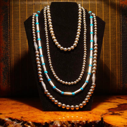 Vintage Navajo sterling silver and turquoise pearl necklace featuring tube and barrel beads with turquoise spacers, displayed on wooden surface, 32 1/2 inches long.