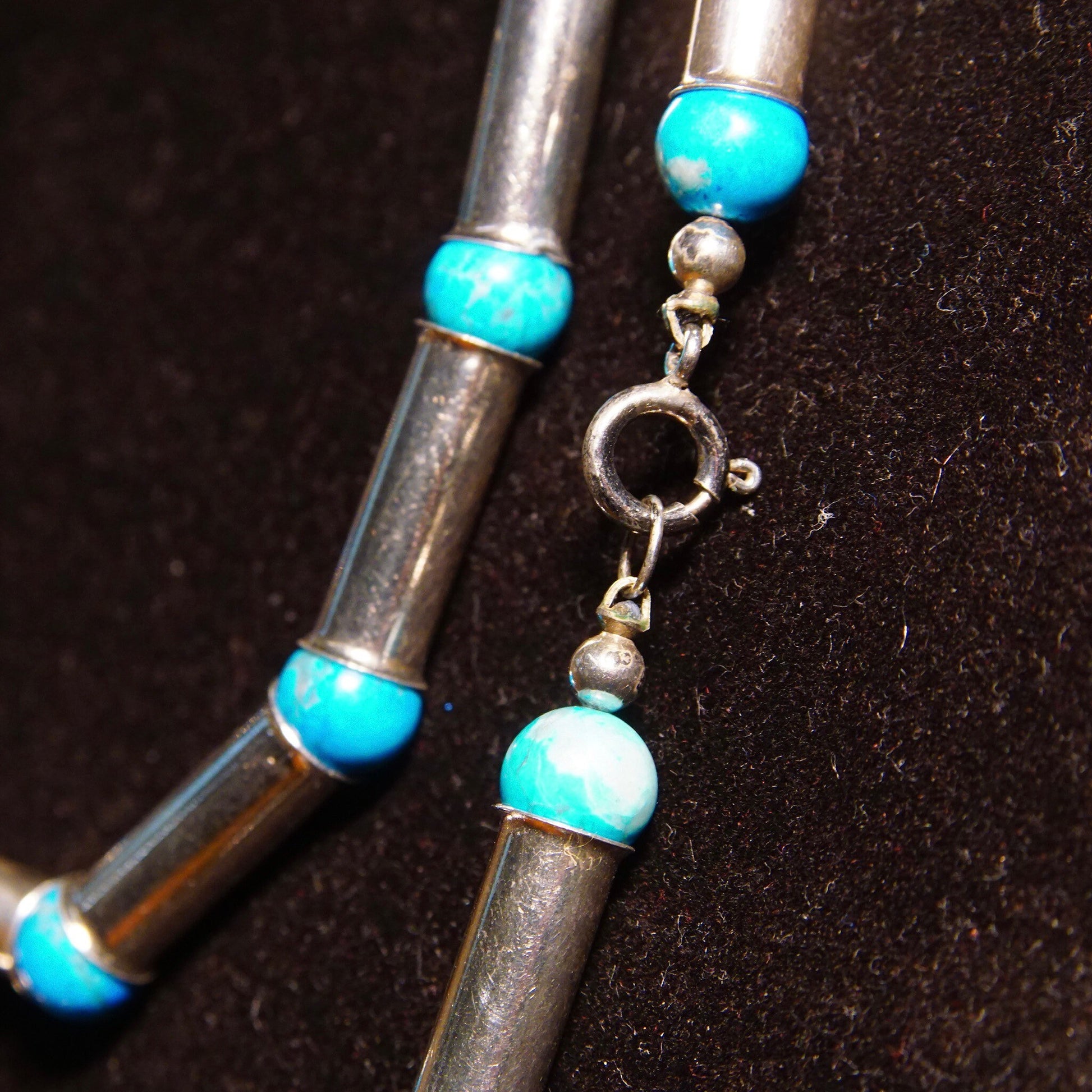 Vintage Navajo Sterling Silver turquoise and pearl barrel bead necklace with blue turquoise spacer beads, measuring 32 1/2 inches long, closeup view on dark textured background