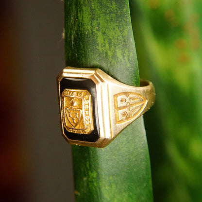 Vintage 1938 10K yellow gold and onyx Trenton High School class ring with crest and "38" engraved, mounted on green stem, close-up view