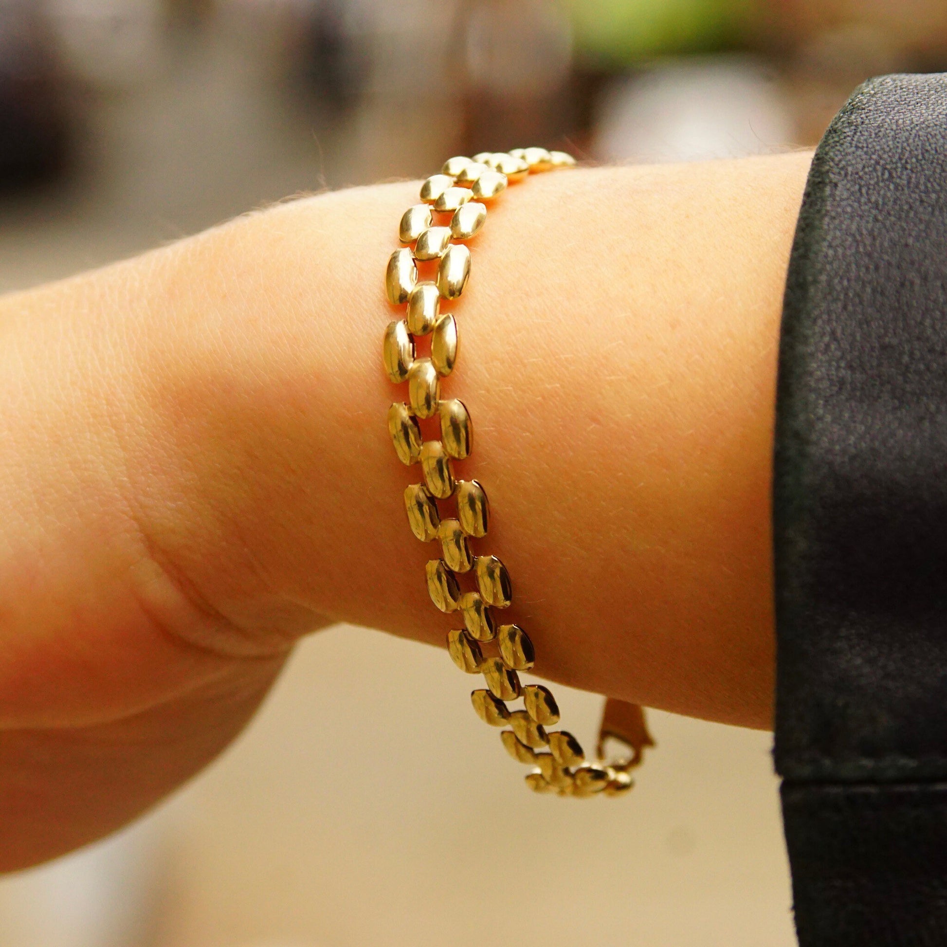 Vintage 10K yellow gold panther link bracelet with puffed multi-row links, measuring 8mm wide and 7 1/2 inches long, shown on a person's wrist.