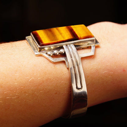 Vintage TAXCO Sterling Silver Tigers Eye Cuff Bracelet featuring a polished rectangular gemstone set in an engraved Mexico 925 silver modernist cuff design measuring 5 1/8 inches long.