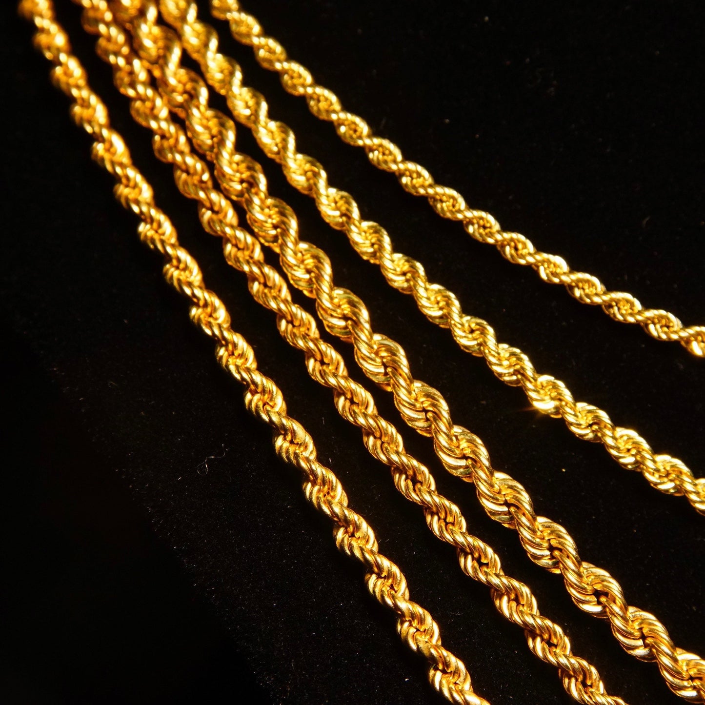 Vintage 14K yellow gold hollow rope chain necklace laid out in diagonal pattern against black background, showing intricate braided link design. Unisex classic chain suitable for both men and women, available in lengths from 16 to 24 inches. Made of 585 gold jewelry.