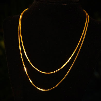 Two vintage 14K yellow gold Italian box chains on black background, 1.5mm wide, solid gold, 585 fineness, pendant chains 16 and 18 inches long.