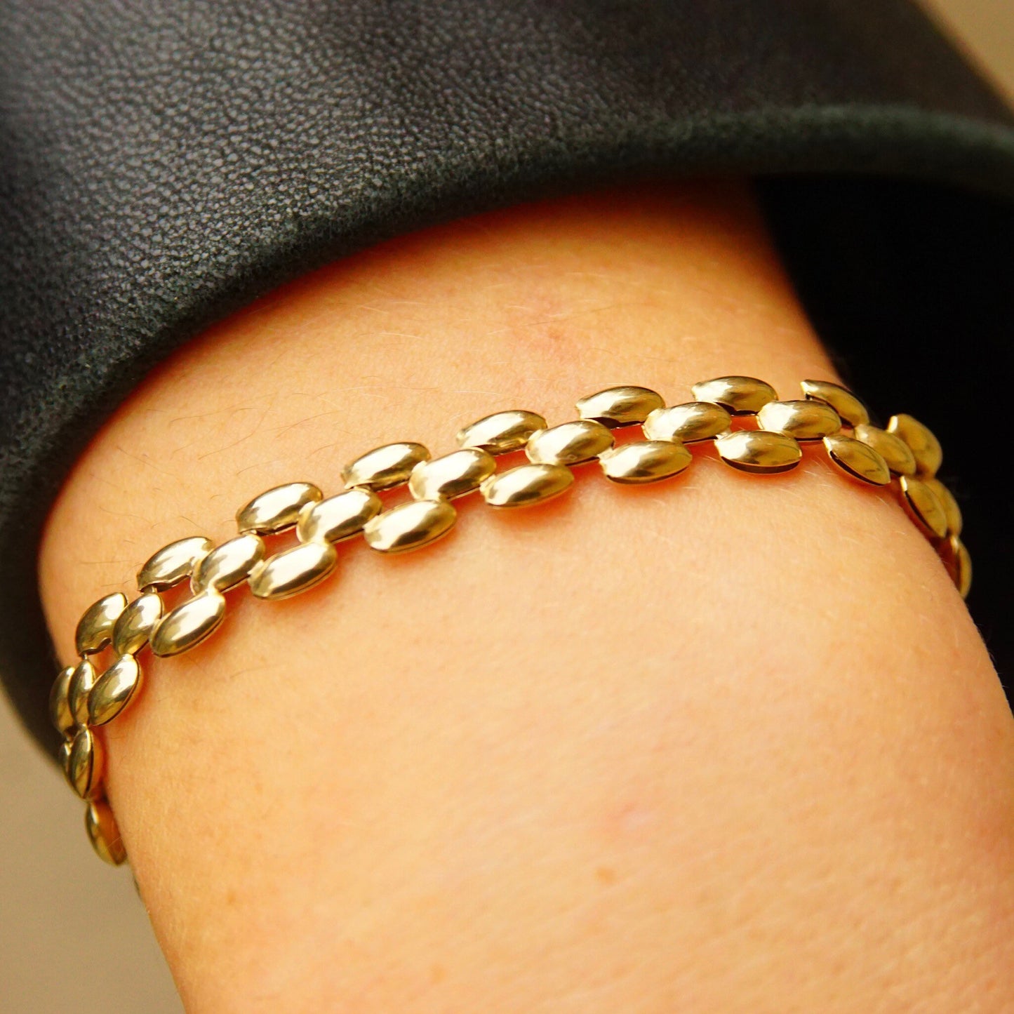 Vintage 10K gold panther link chain bracelet with 8mm multi-row puffed yellow gold links, measuring 7 1/2 inches long, resting on a person's wrist.