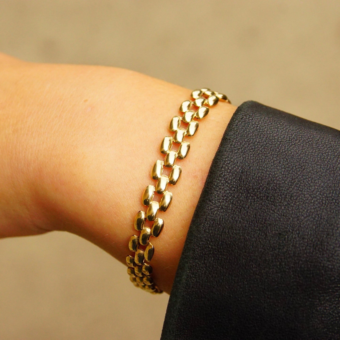 Vintage 10K gold panther link chain bracelet on wrist, featuring 8mm multi-row puffed yellow gold links, measuring 7 1/2 inches long.