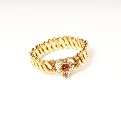 Antique Victorian gold-filled stretch band bracelet featuring a heart charm with diamond accent, shell inlay, faux ruby, and floral embellishments on an expandable s-link band measuring approximately 5 inches in length.