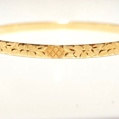 14K yellow gold bangle bracelet featuring intricate diamond-cut floral and leaf motifs, 5mm wide, perfect for stacking or wearing solo.