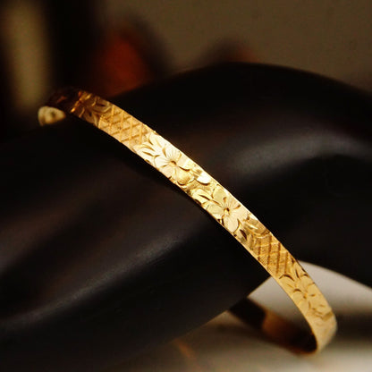 14K yellow gold bangle bracelet with intricate diamond-cut floral designs, 5mm wide, ideal for stacking or wearing alone.