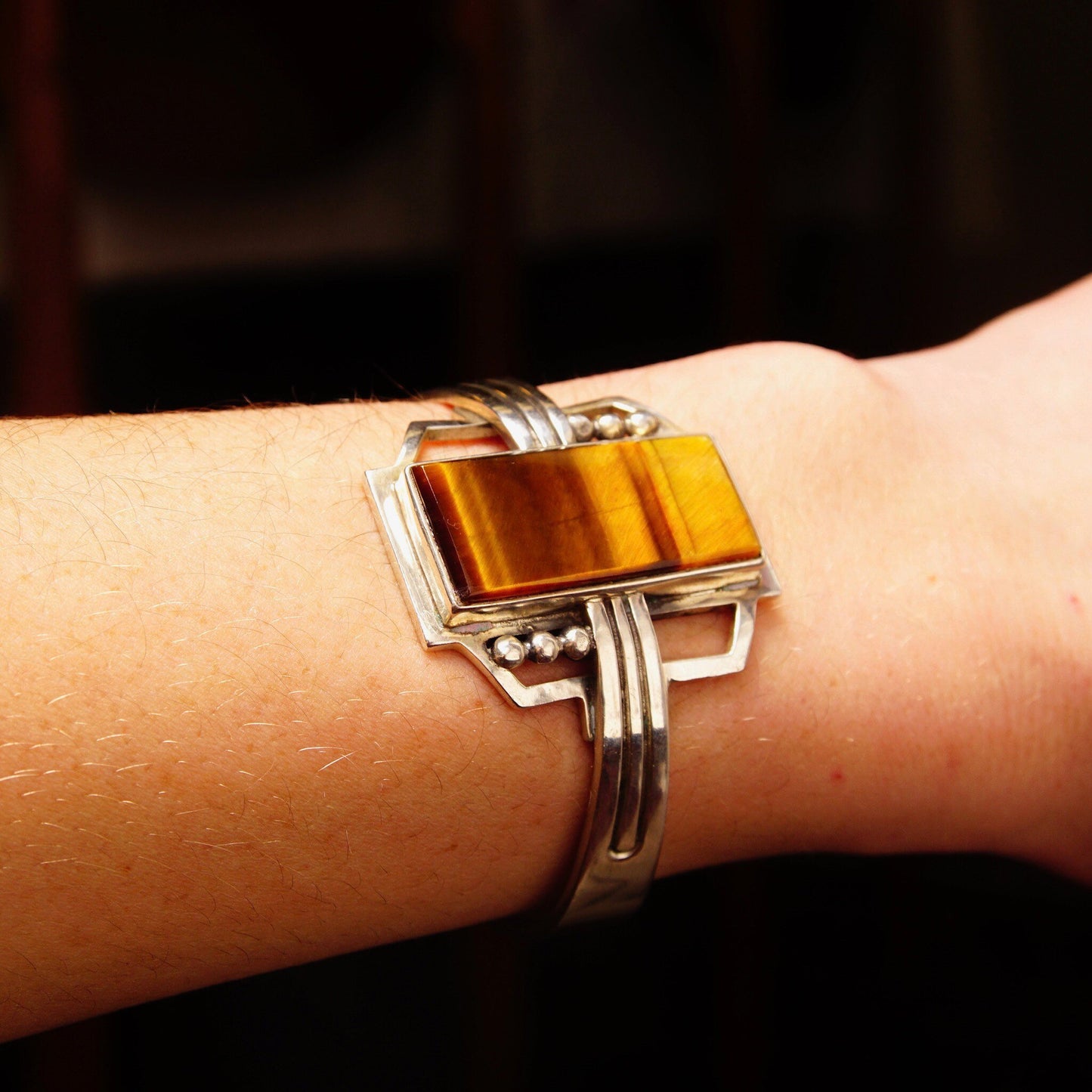 Vintage TAXCO Sterling Silver Tigers Eye Modernist Cuff Bracelet on wrist with rectangular polished gemstone, engraved Mexico 925 hallmark, measuring 5 1/8 inches long