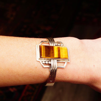 Vintage Sterling Silver and Tigers Eye Cuff Bracelet made in Taxco, Mexico, featuring a polished rectangular gemstone set in a modernist design. The bracelet is stamped "Mexico 925" and measures approximately 5 1/8 inches in length.