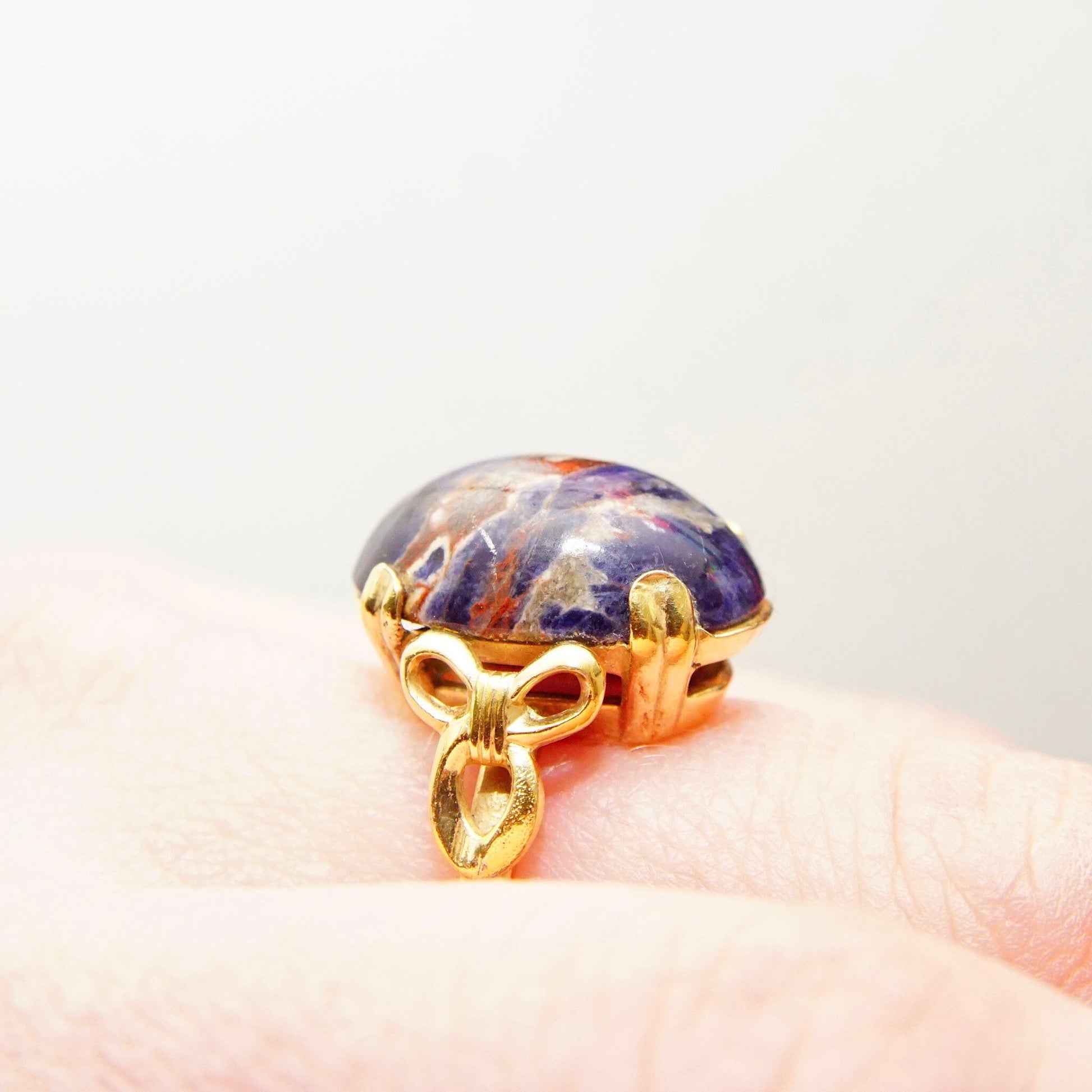 Vintage 10K gold-filled ring with dark blue lapis lazuli cabochon gemstone featuring natural inclusions, accented by yellow gold ribbon design, size 8 US.