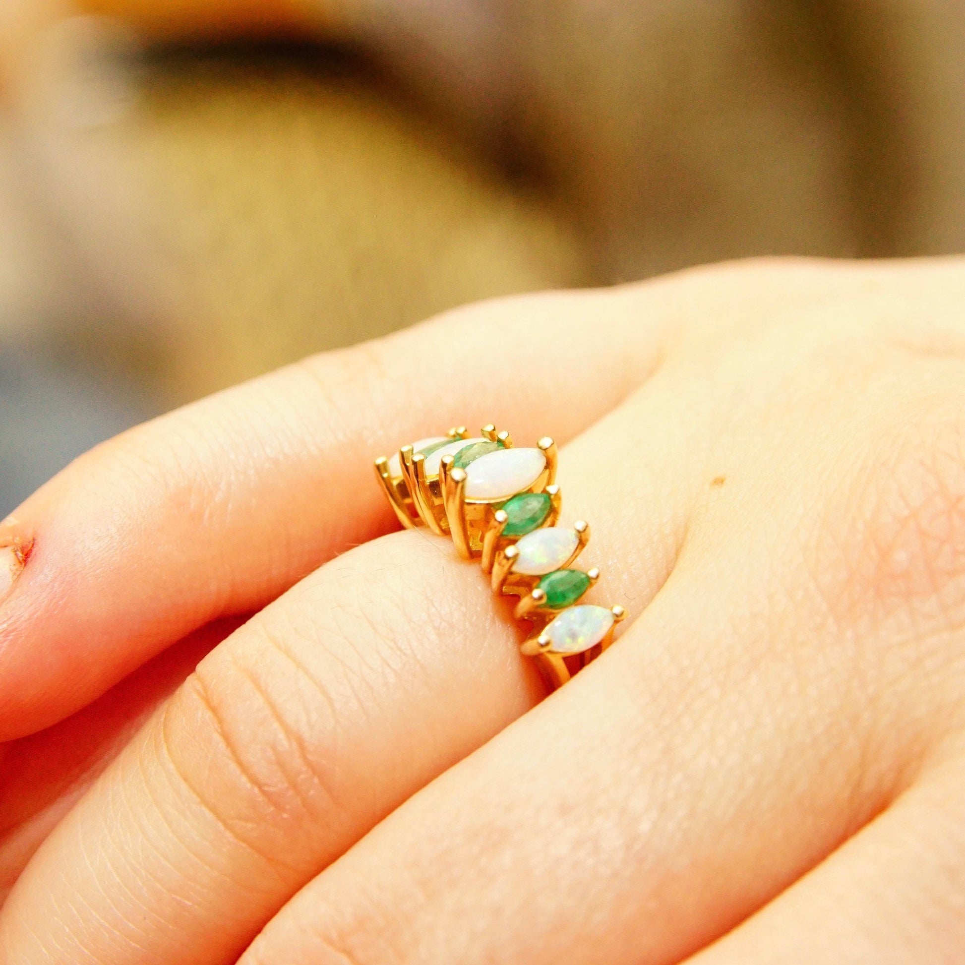 14K gold cocktail ring with marquise-cut opal center stone surrounded by emerald accents on a woman's hand, size 6 1/4 US, estate jewelry