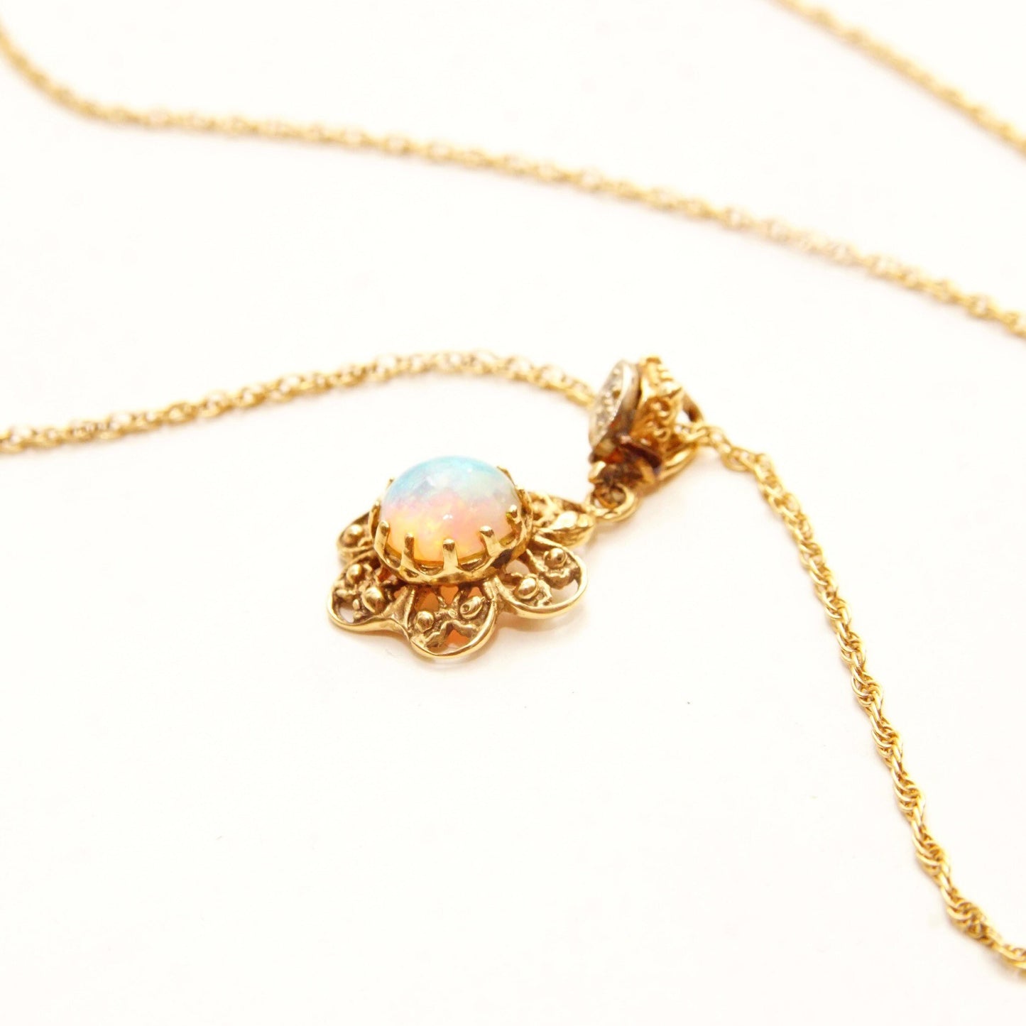 14K gold filigree opal flower pendant necklace with diamond accent on delicate rope chain against white background