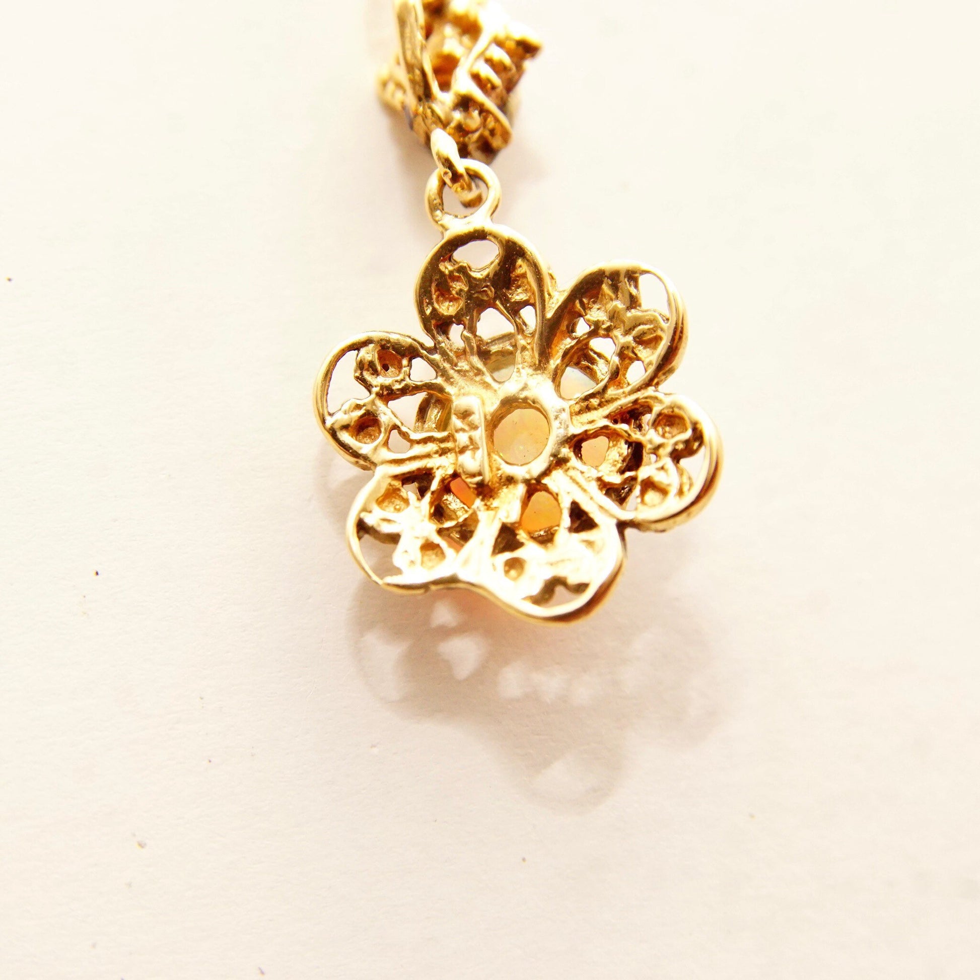 14K gold filigree flower pendant necklace with opal gemstone cabochon center and diamond accents on bail, featuring delicate 1.5mm loose rope chain, 21 inches long.