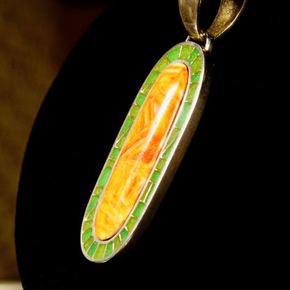 Vintage 925 sterling silver long oval pendant necklace with orange carnelian agate and green aventurine mosaic inlay, featuring a large silver bail, measuring 1 3/8 inches in length.