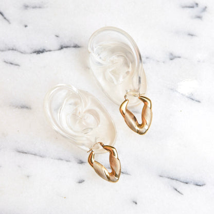 14K yellow gold puffed V-shaped hoop earrings with textured striped design and hinged ear wire, small to medium size measuring 1 3/8 inches long, on white marble background