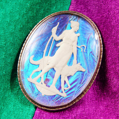 Alt text: Vintage Art Deco sterling silver cameo brooch featuring an iridescent butterfly wing sulfide cameo depicting a Grecian goddess, made in England, measuring 1 3/4 inches in length, displayed on a colorful textured background.