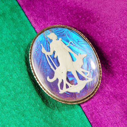 Vintage Art Deco sterling silver butterfly wing cameo brooch pin depicting iridescent silhouette of Grecian goddess figure on vivid teal and magenta background, made in England, measuring 1 3/4 inches long.