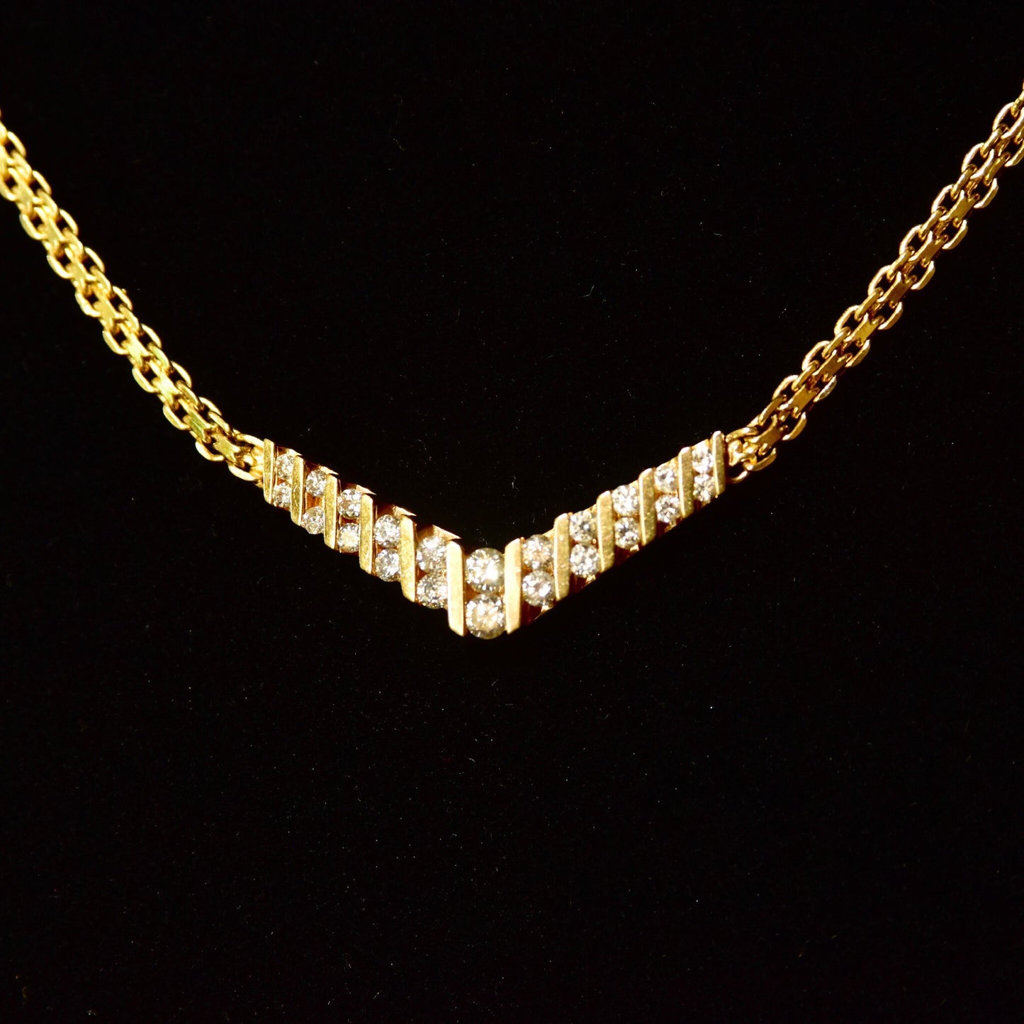 14K yellow gold diamond chevron necklace featuring channel set brilliant cut diamonds in a V-shaped pendant on a delicate mesh link chain, 15 1/4 inches long.