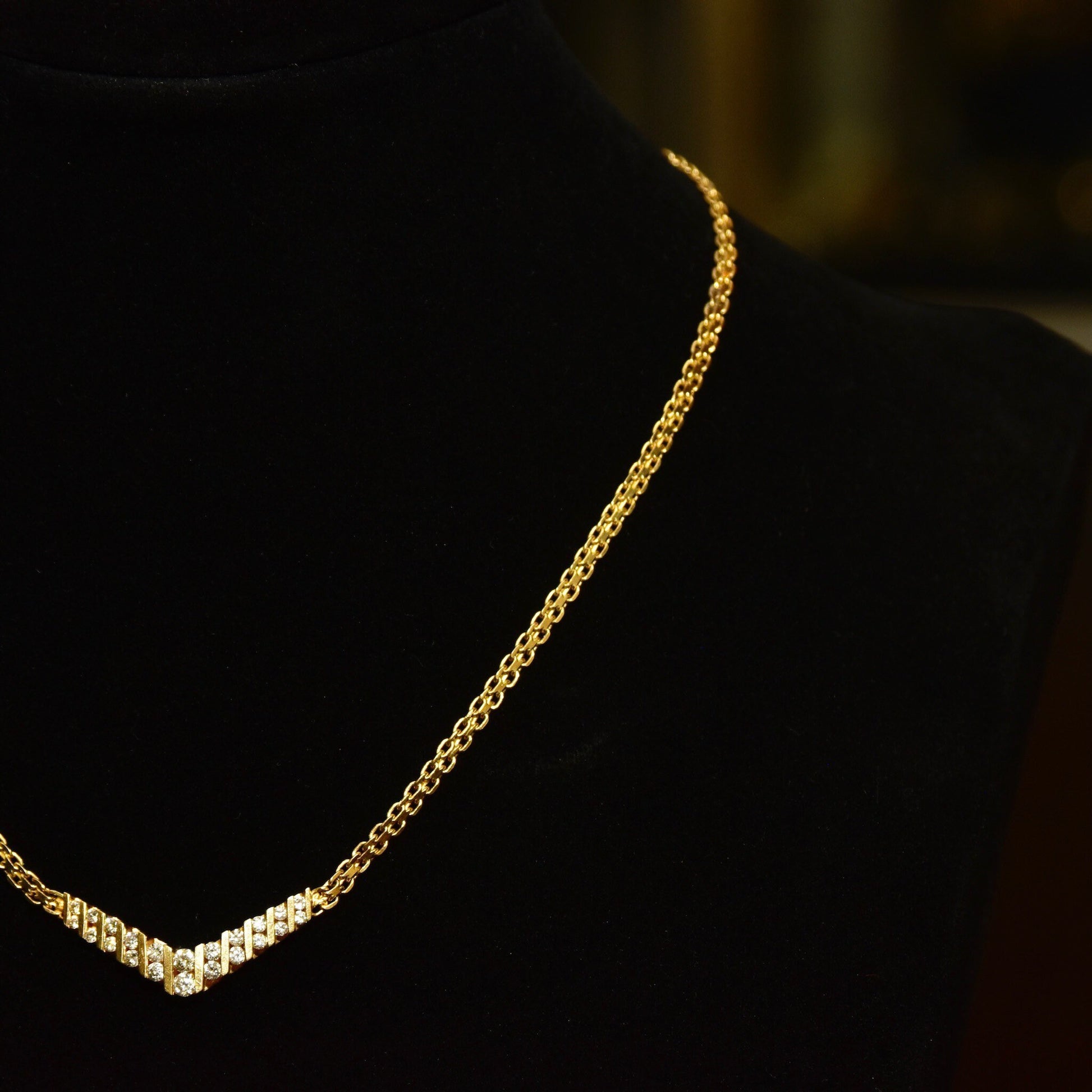 14K yellow gold chevron diamond necklace with channel set brilliant cut diamonds on a mesh link chain, 15 1/4 inches long.